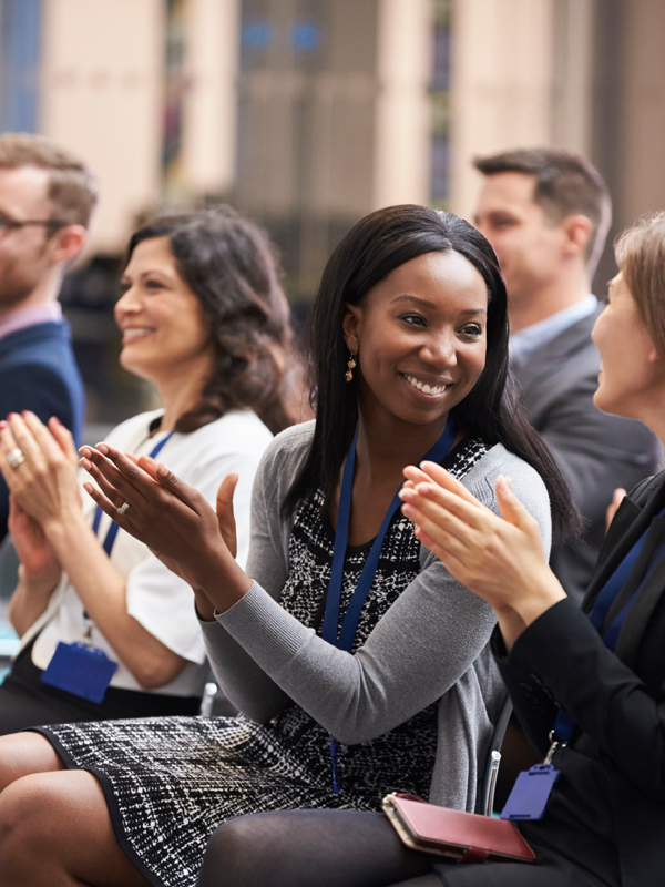 2023 Staff Promo Header - post - apr2025 Photo of staff smiling and clapping in a group setting
