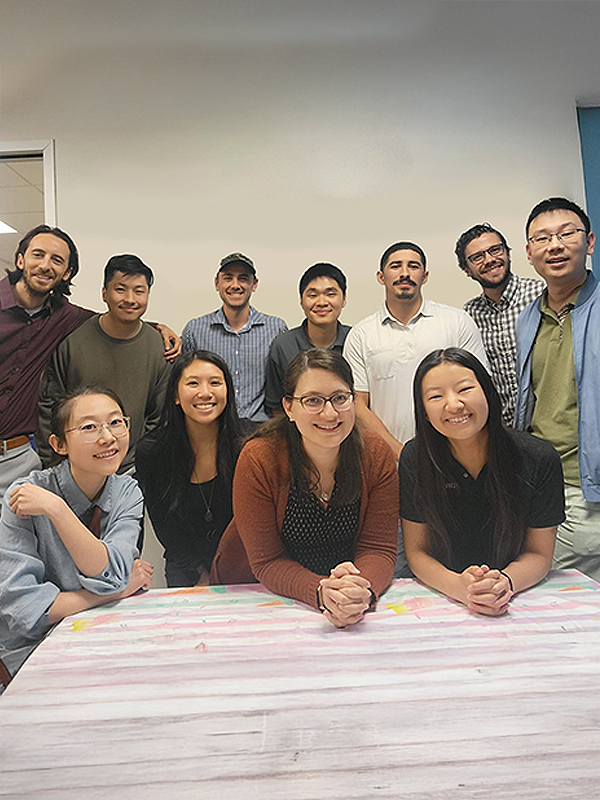 Staff gathered around a table posing for a photo