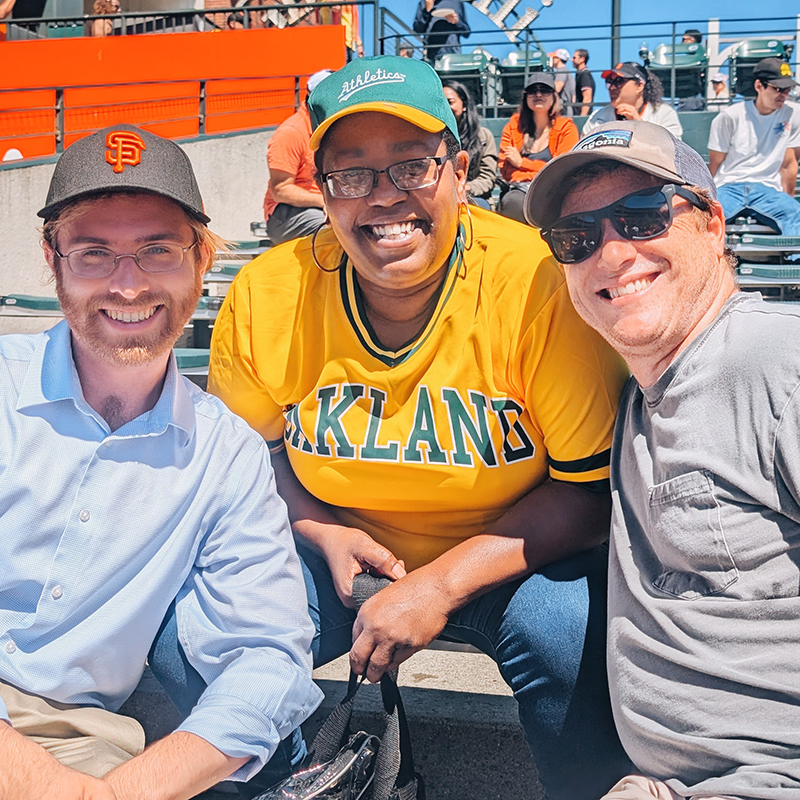 Baseball - Page - Jan2025 Three staff members enjoying an afternoon at a baseball game