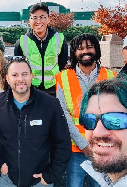 Staff selfie - Page - Jan2025 Four people pose for a selfie at a company event