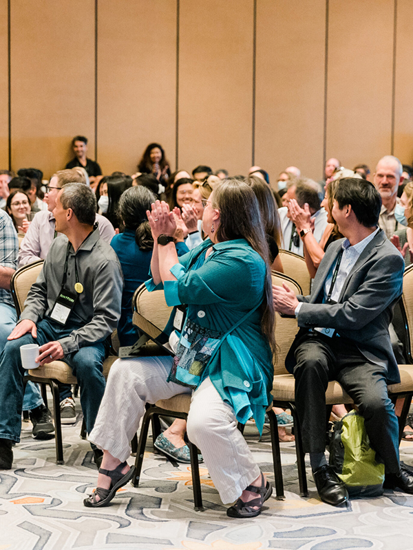 2024 New Shareholders - post - Apr2025 Image of staff applauding in a large group setting