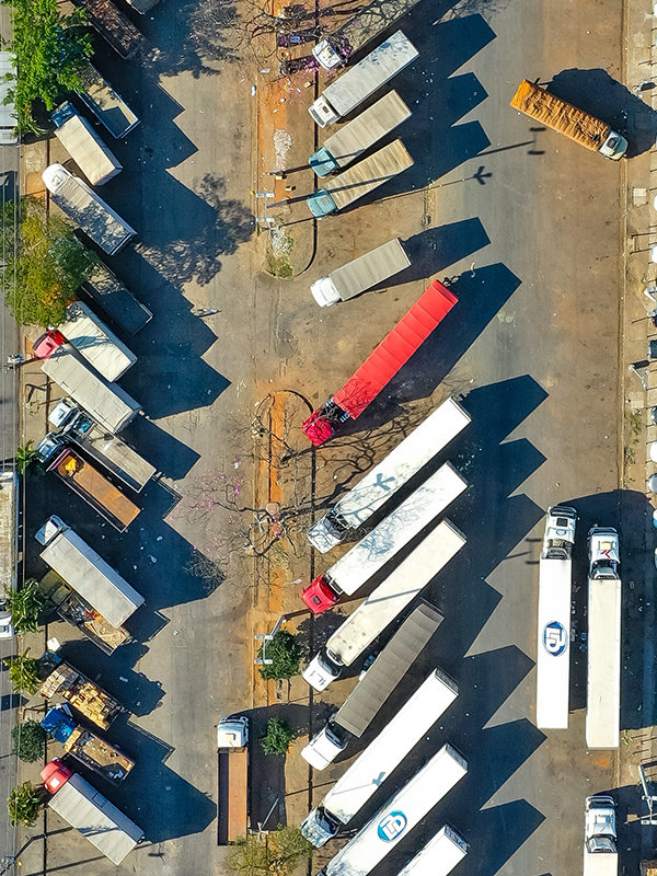 Several freight trucks parked in a crowded truck parking lot