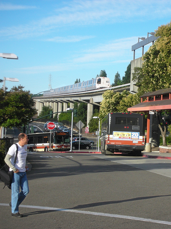 Transforming Transit Access Header - post - apr2025 BART station showing multimodal ways of arriving including people walking and arriving by bus