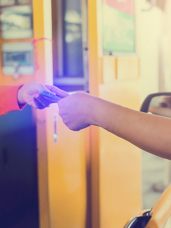 Driver pay for the expressway Person driving a car is paying money to a cashier for a toll road