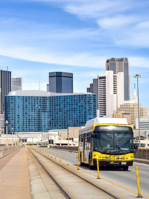 New Office Dallas Header - post - May2022 Woman lifting bicycle into a train as she boards