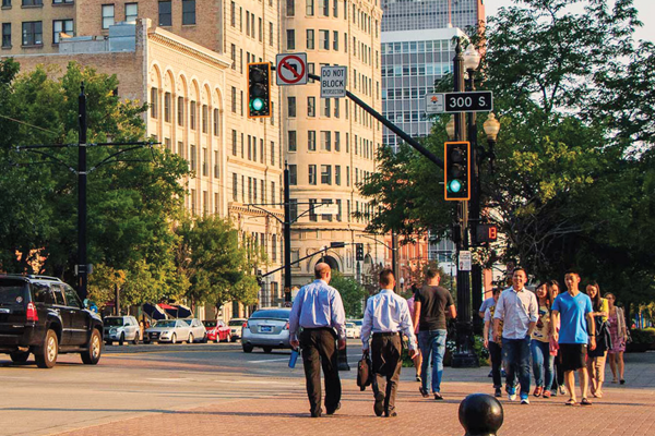 Group of people crossing a crosswalk with cars passing by