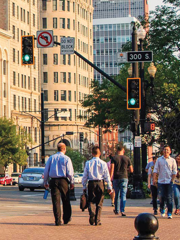 Group of people crossing a crosswalk with cars passing by