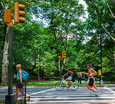 People jogging and cycling through a crosswalk