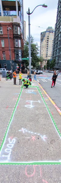 SDOT crew drawing in the chalked outline of a parking corral for electric scooters and bikes.