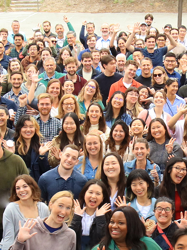 A group of staff members smiling and waiving at the camera